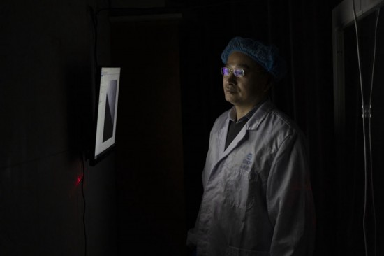 阮昊研究员在上海光机所光学实验室观察写入试验进展（2月29日摄）。